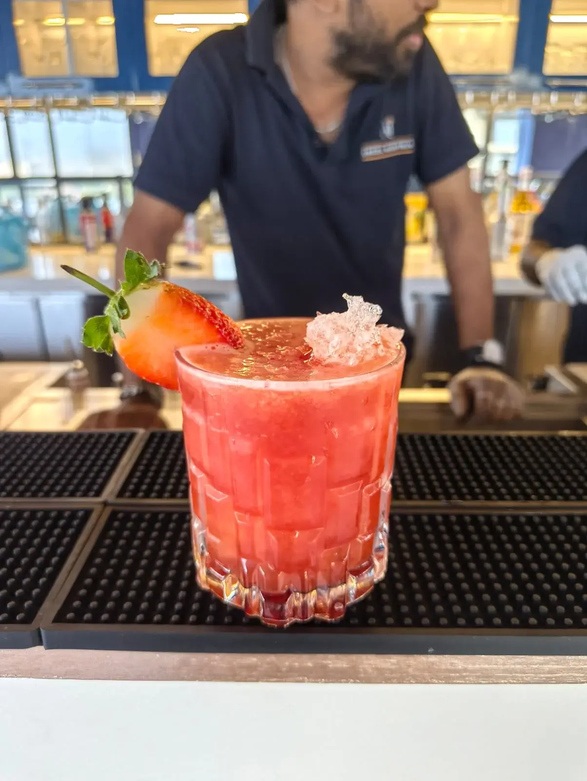 Live bartending Dhaka pouring a strawberry topped cocktail