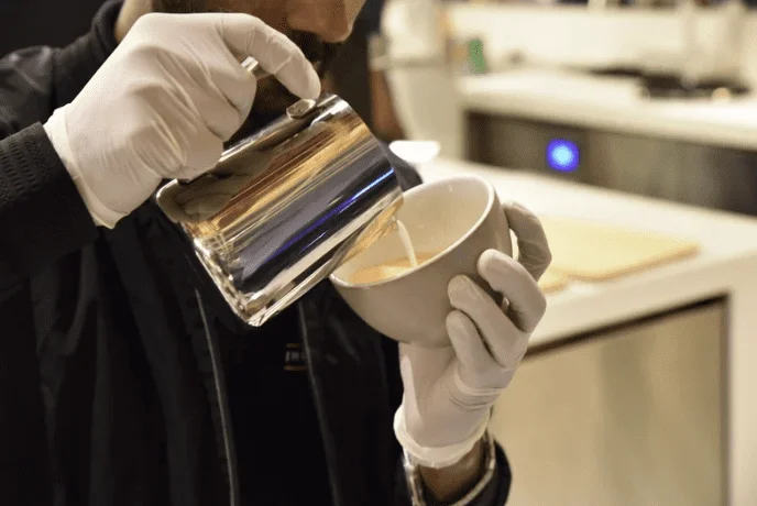Barista pouring latte art at a Gulshan specialty coffee cafe
